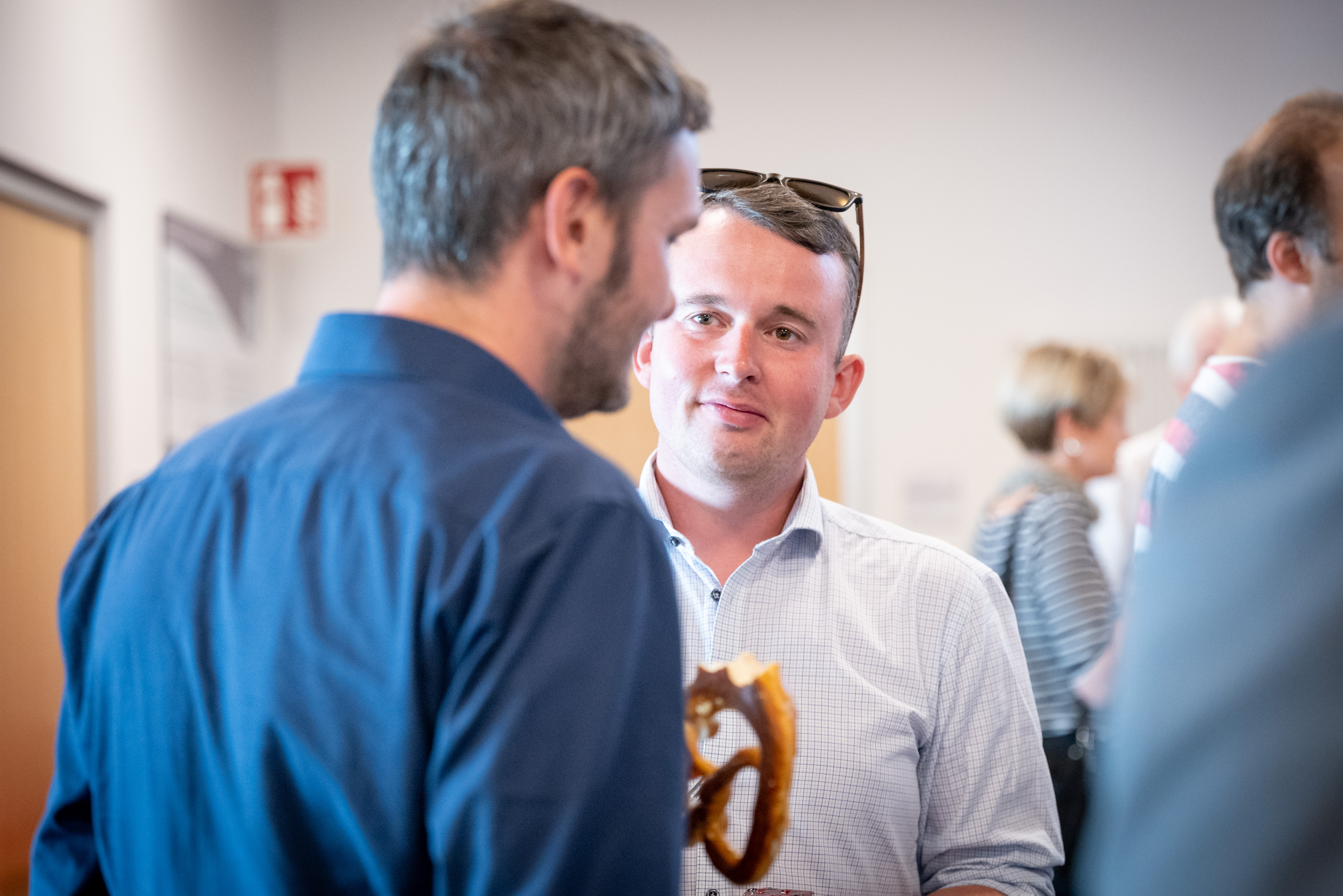 Zwei Männer im Gespräch bei einer Networking-Veranstaltung.